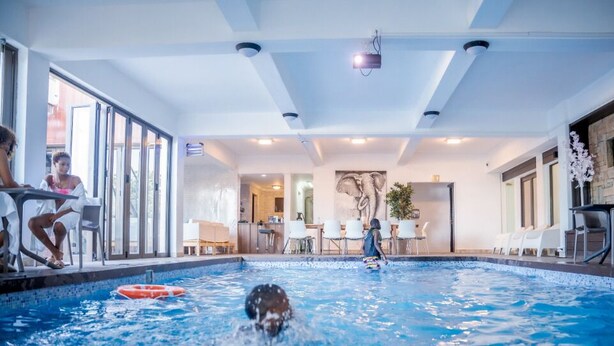 Sisätiloissa sijaitseva uima-allas, jossa on sallittu koirien uinti, ruokailutila ja vastaanottotiski.