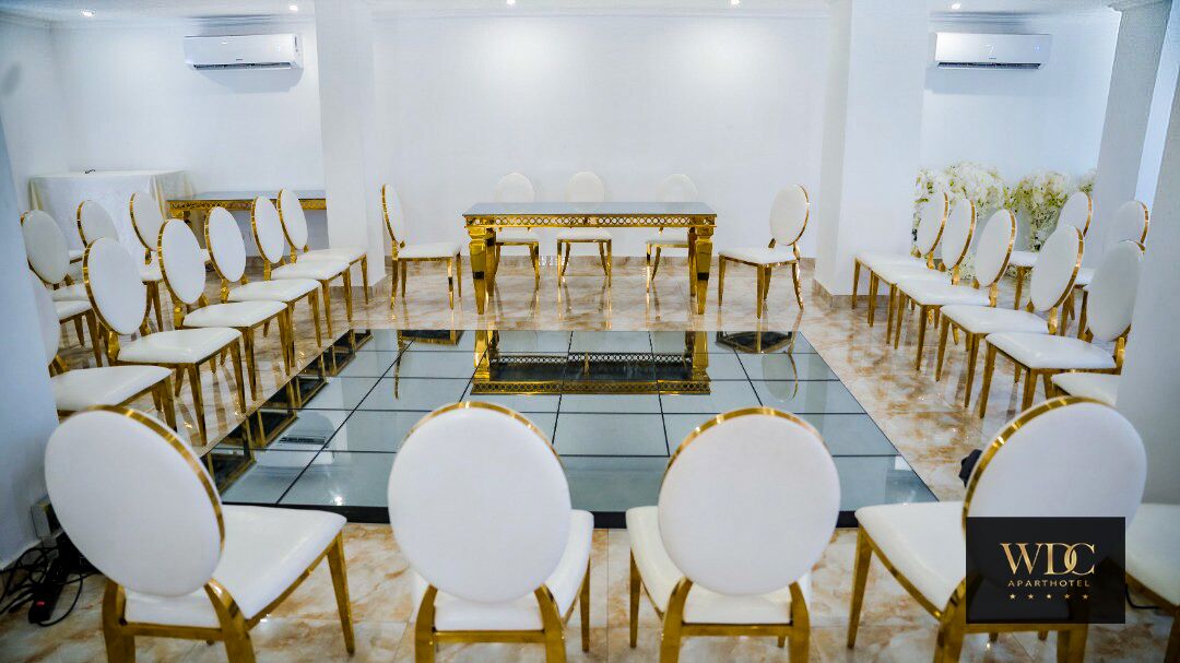 Un salón de conferencias con una larga mesa y sillas dispuestas para una reunión.