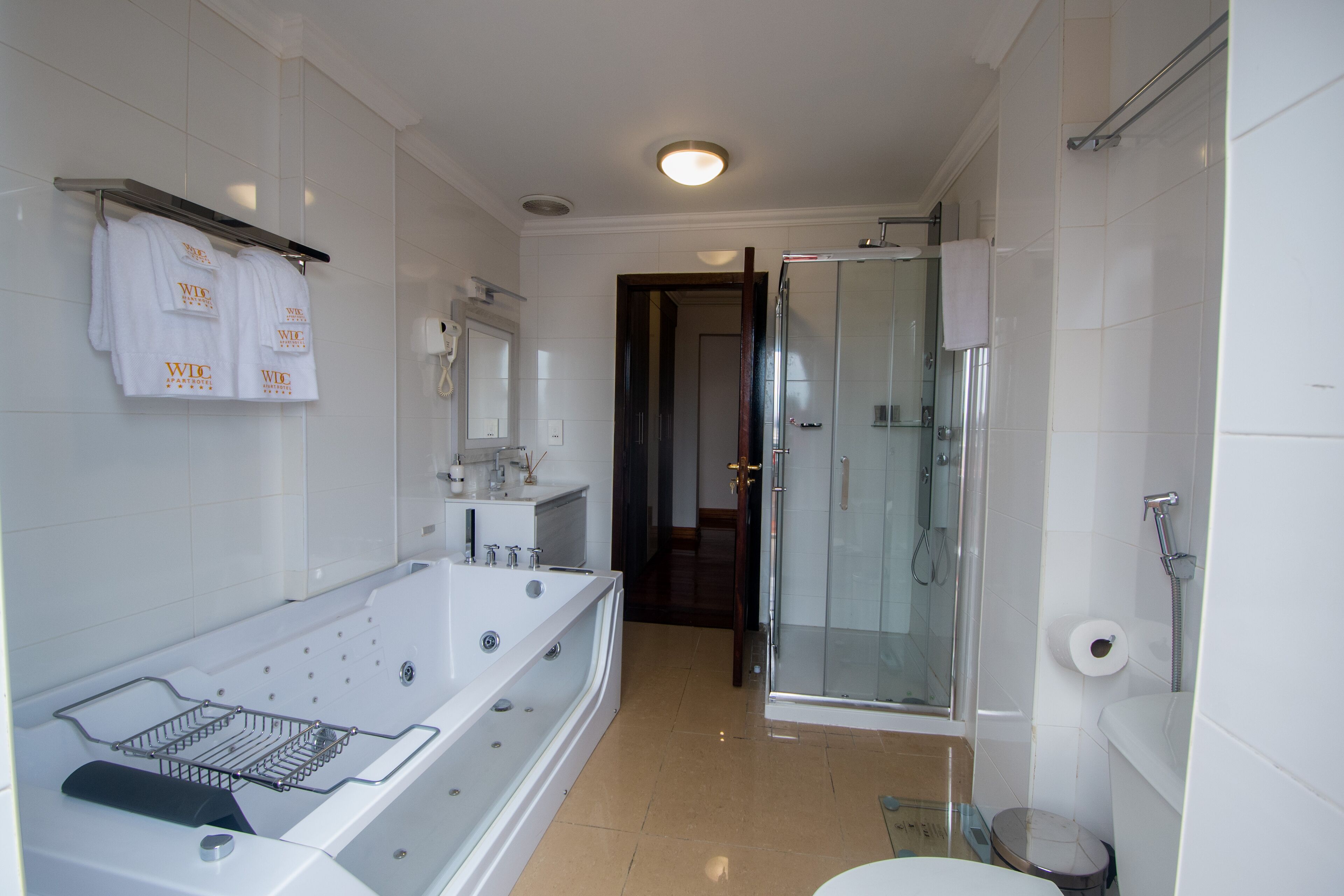 A modern bathroom with a large bathtub, a glass-enclosed shower, and a toilet.