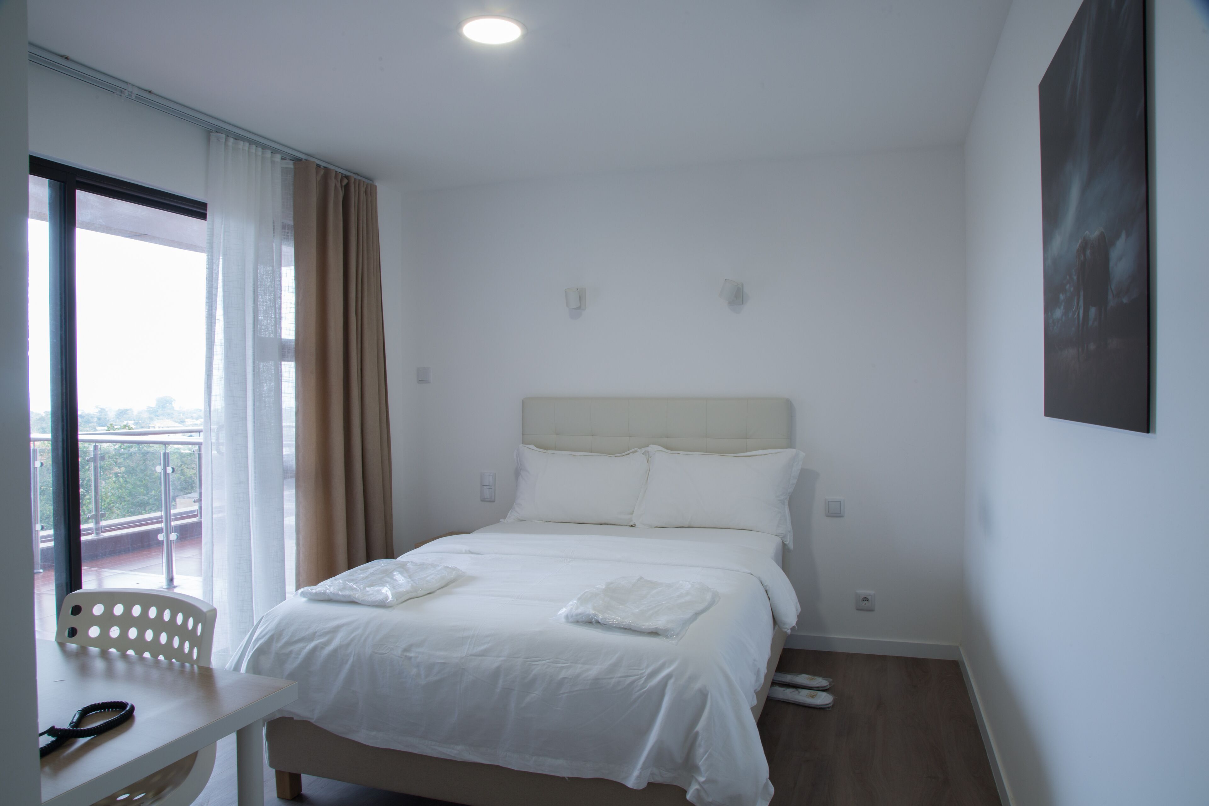 Una habitación de hotel con una cama, un escritorio y una silla.