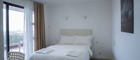 Una habitación de hotel con una cama, un escritorio y una silla.