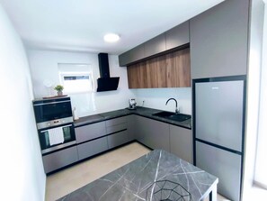 Departamento, varias camas | Cocina privada | Refrigerador, microondas, horno y parrilla de estufa 