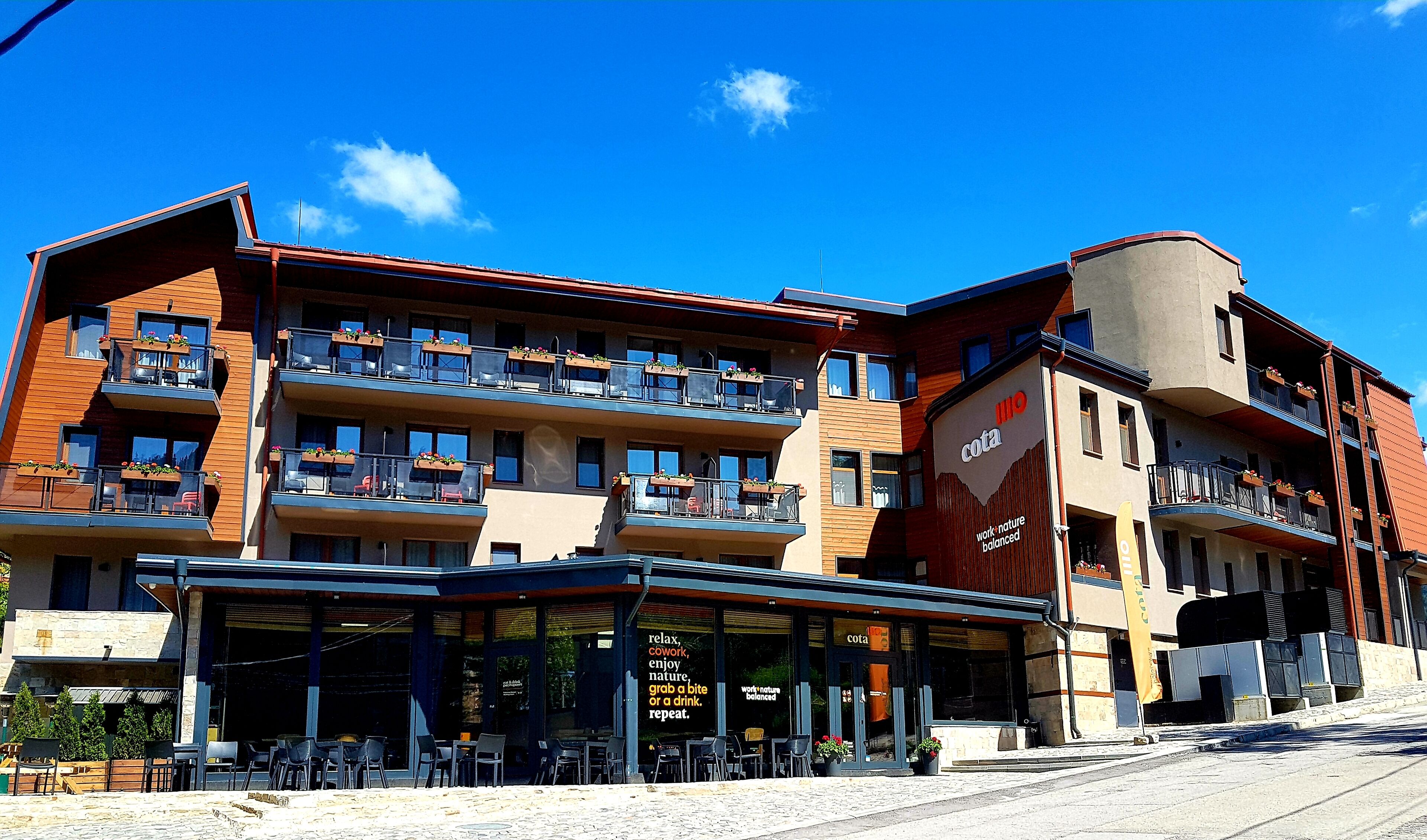 Un hotel de varios pisos con asientos al aire libre y balcones.
