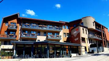 Un hotel de varios pisos con asientos al aire libre y balcones.