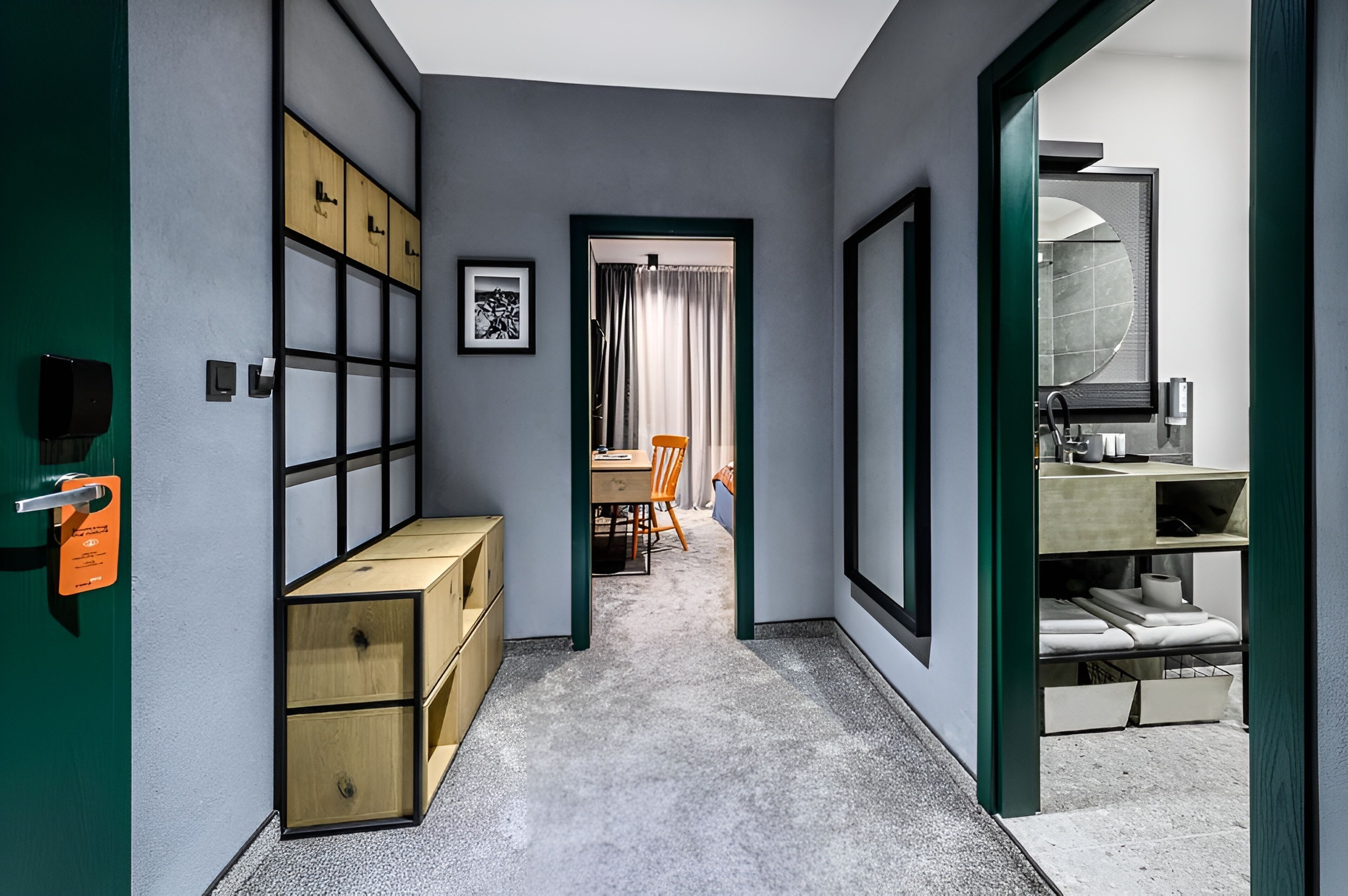 A hallway with storage boxes, a desk, and a chair.