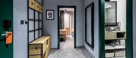 A hallway with storage boxes, a desk, and a chair.