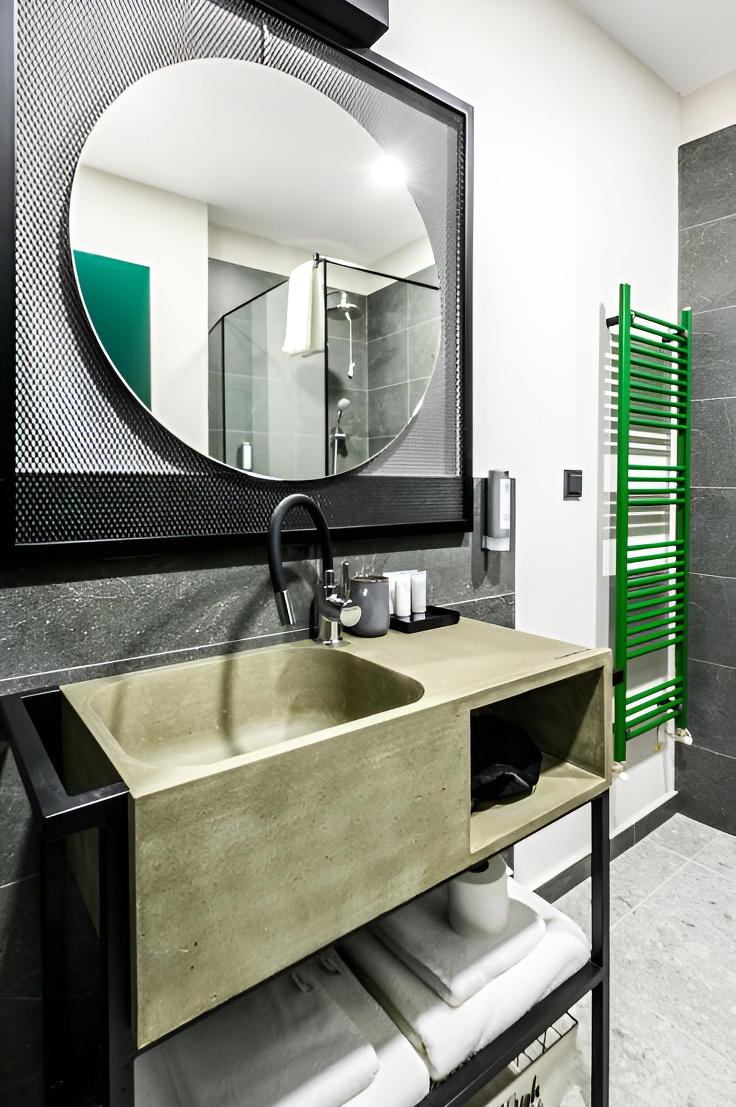 Un bagno moderno con uno specchio grande, un lavandino e un appendi-asciugamani verde.