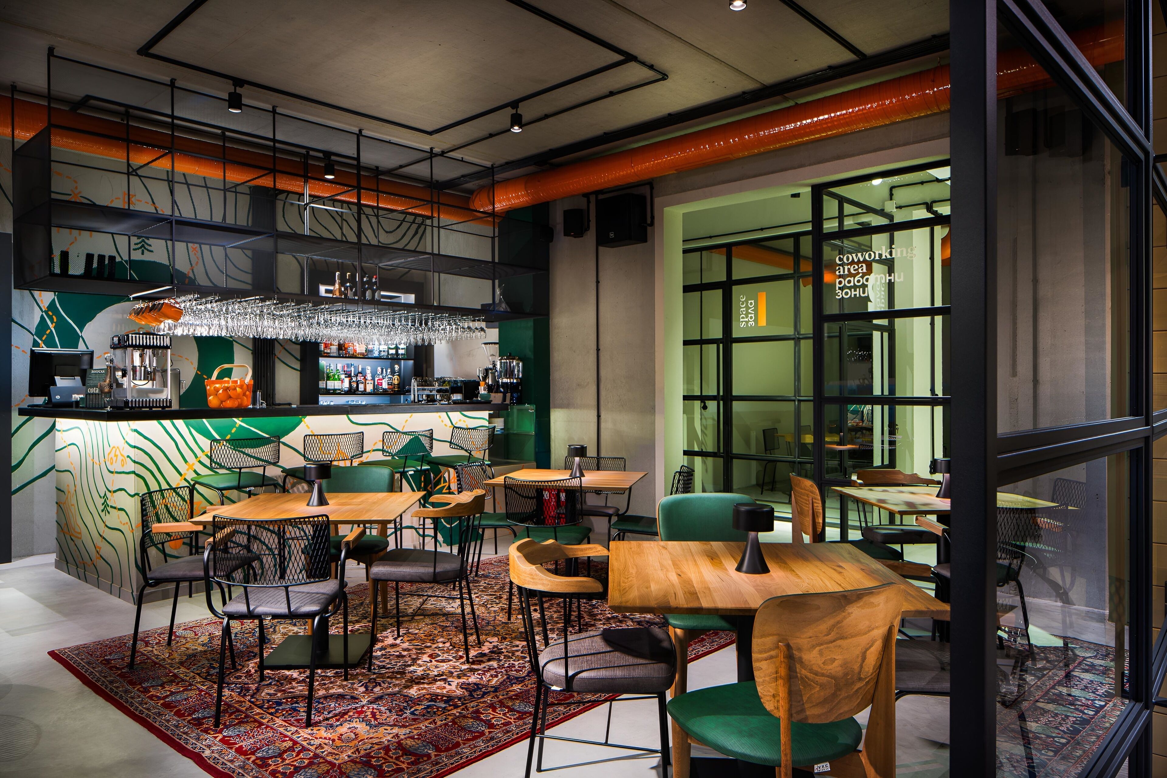 Zona de bar moderna con mostrador, asientos y un ventanal grande.