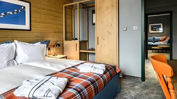 A hotel room with a bed, a wardrobe, a desk, and a chair.