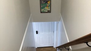 A wooden staircase with white walls and a door at the top. - Beautiful 4 Bedroom short walk to the Pier, Beach, & Attractions (Old Orchard Beach)