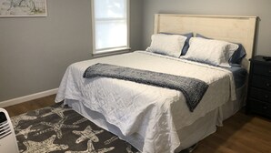 A bedroom with a bed, a window, a wall-mounted sign, and a floor lamp. - Beautiful 4 Bedroom short walk to the Pier, Beach, & Attractions (Old Orchard Beach)