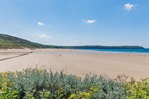 A beach with a wide sandy area, a clear sky, and distant hills. - 6 Bed in Woolacombe (oc-mouro) (Woolacombe)