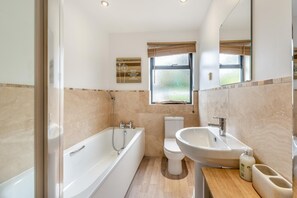 A modern bathroom with a bathtub, toilet, and sink. - 6 Bed in Woolacombe (oc-mouro) (Woolacombe)