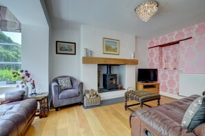 Una sala de estar acogedora con chimenea, televisor y asientos cómodos.