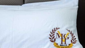 En hvid pude med et logo og tekst der siger "MGH MBALE GOLF VIEW HOTEL".