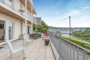 A balcony with outdoor seating, a view of a river, and a cityscape in the background. - 2 Bed in Kingswear (oc-bc129) (Waterhead)