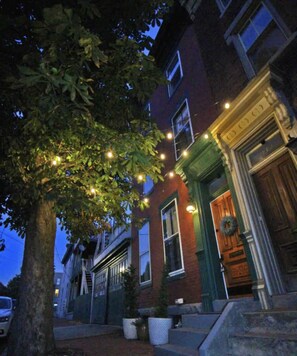 A building with a green door and a wreath, surrounded by trees and string lights. - Historic Harrisburg Home (Harrisburg)