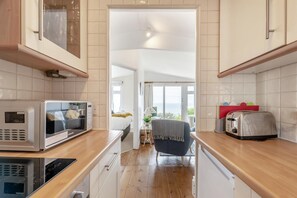 A modern kitchen with a microwave, toaster, and a view to the outside.