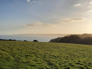 A grassy field with a distant view of a body of water and hills. - 2 Bed in Stoke Fleming (oc-bc777) (Stoke Fleming)