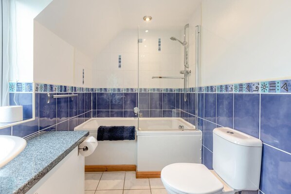 A bathroom with a bathtub, toilet, and sink.