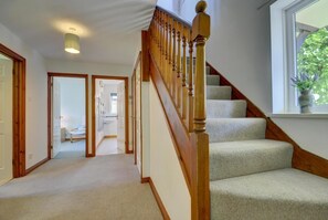 A staircase with wooden balusters and carpeted steps leading to a landing.