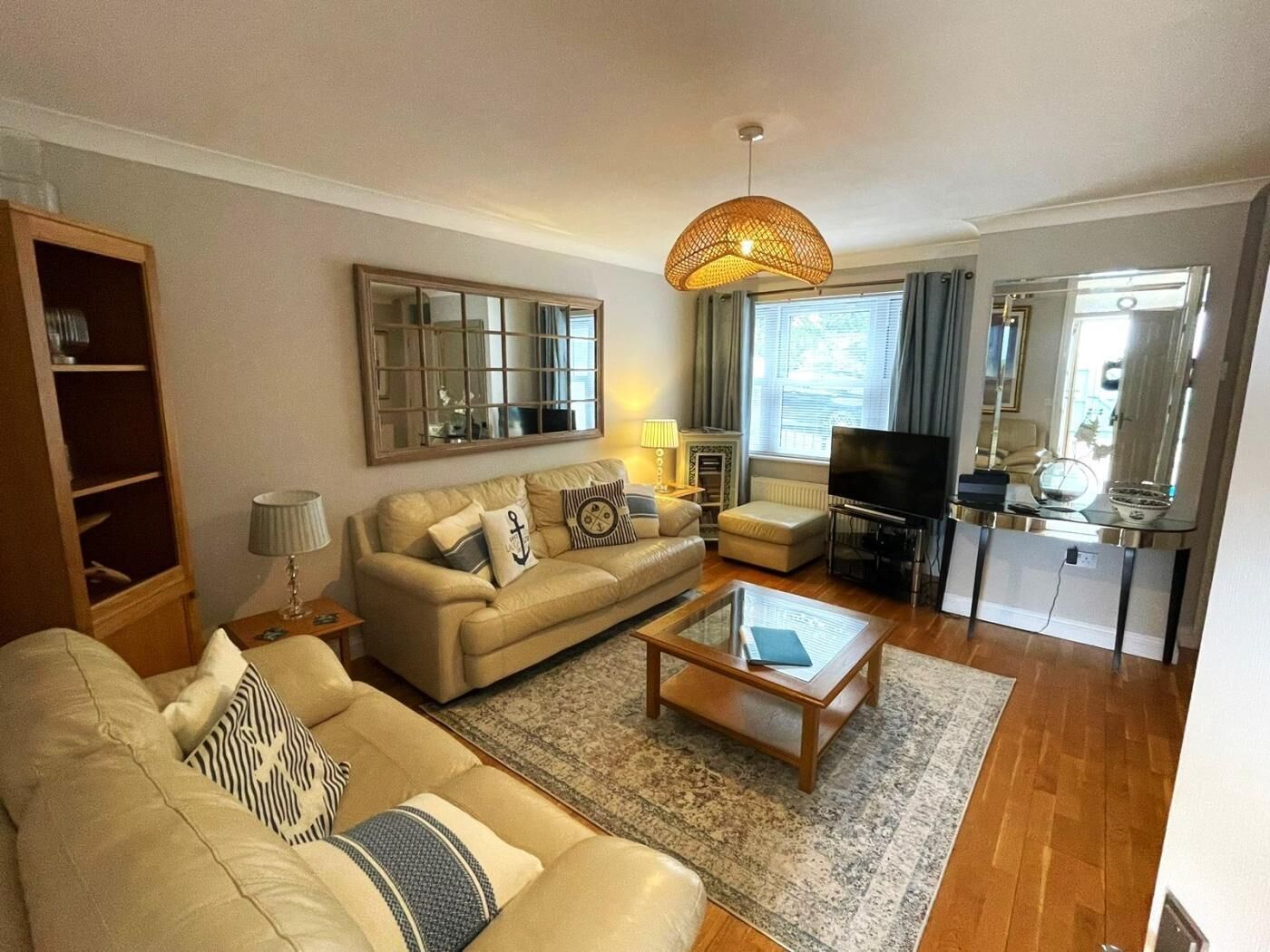 Ein Wohnzimmer mit Sofa, Couchtisch, Fernseher und Kamin.