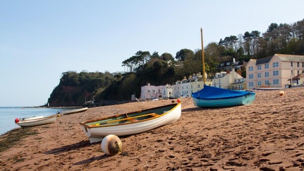 A sandy beach with several boats, a buoy, and buildings in the background. - 2 Bed in Shaldon (oc-starco) (Shaldon)
