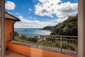 A balcony with a view of a coastal landscape, including a body of water and a hilly area with vegetation. - 1 Bed in Torquay (oc-kilmlo) (Torquay)