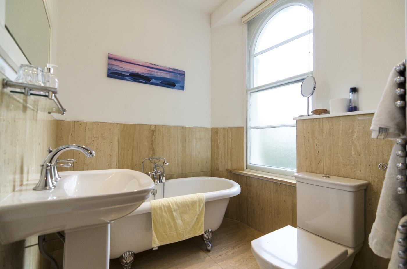 A bathroom with a freestanding bathtub, a sink, and a toilet.