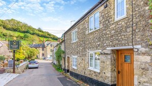 A stone building with a wooden door, a sign for 'The Haven 9,' and a car parked on the street. - 2 Bed in Branscombe (oc-mbhave) (Branscombe)