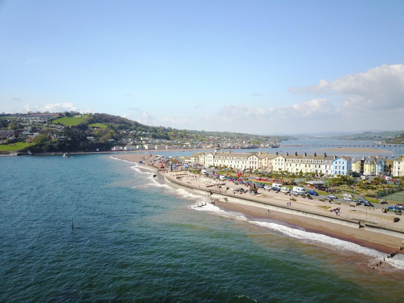 A coastal town with a promenade, buildings, and a view of the sea.