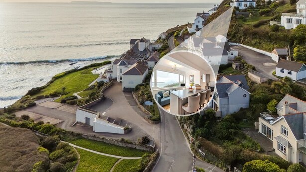 A coastal residential area with houses, a road, and a view of the sea.