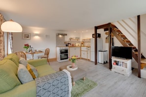 A modern apartment with a living room, kitchen, and dining area.