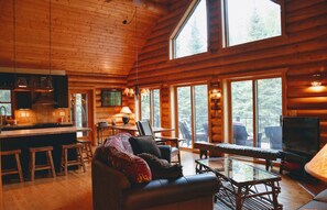 A cozy cabin interior with a kitchen, dining area, and seating space.