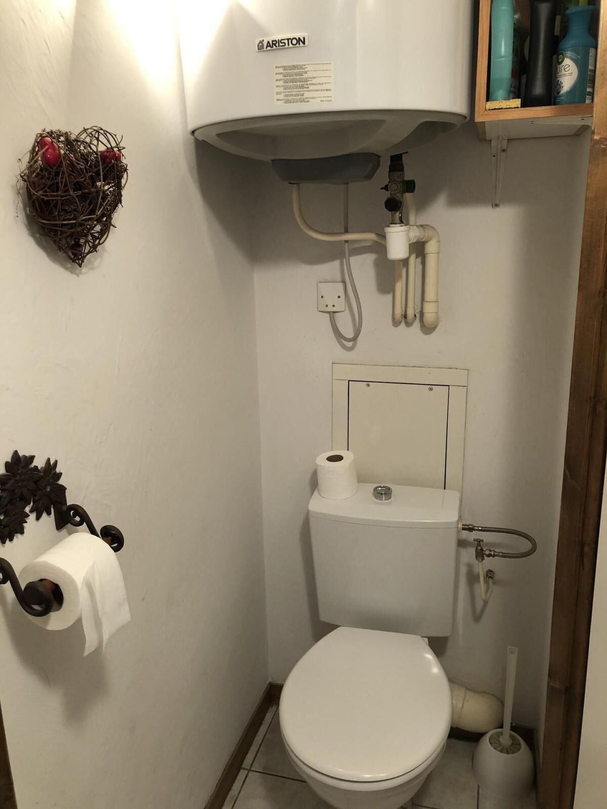 A small bathroom with a toilet, a bidet, and a water heater.