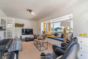 Televisie, een open haard, boeken en een kantoor