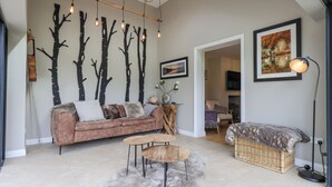 A modern living room with a sofa, a coffee table, and a wall-mounted light fixture.