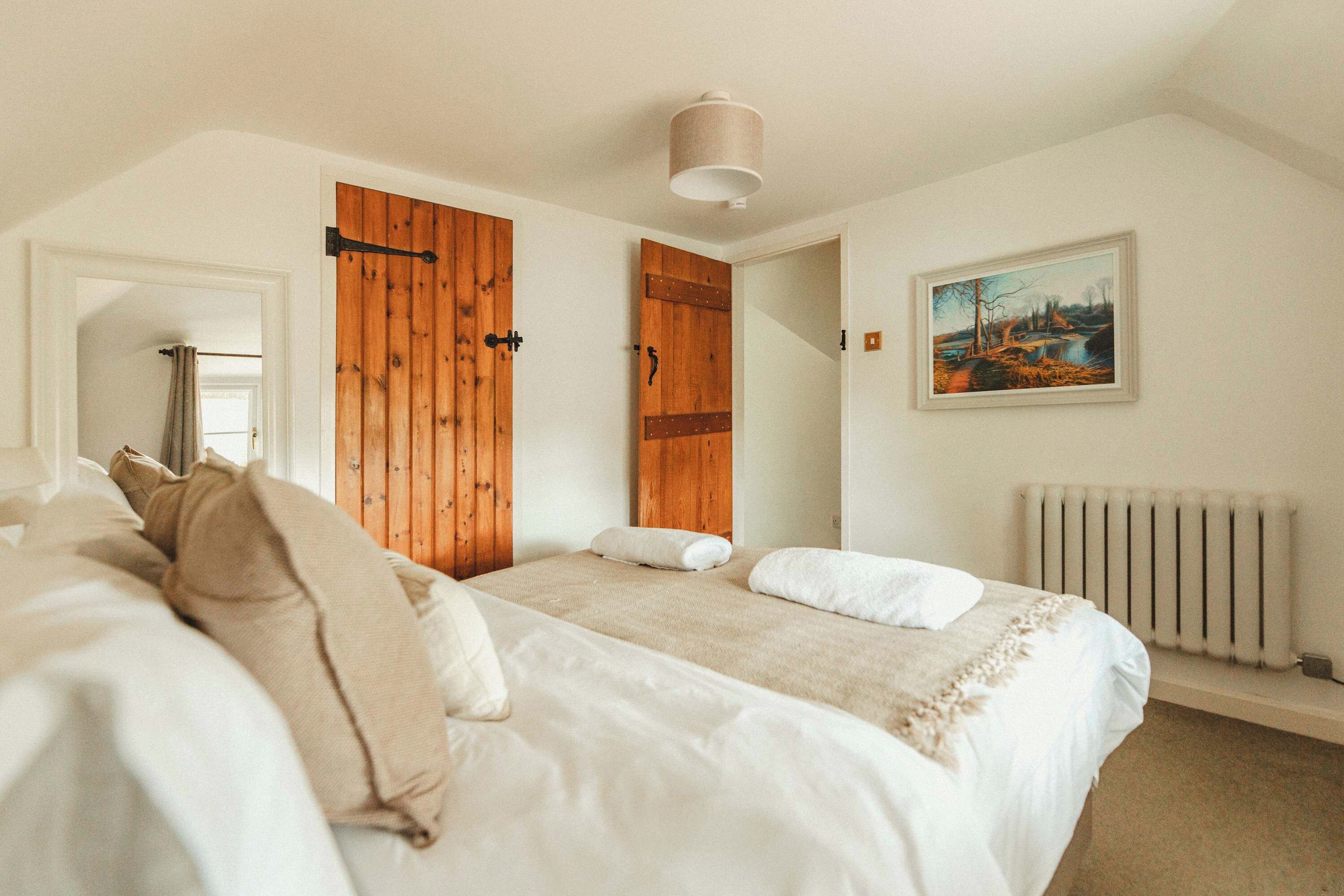 Un dormitorio con una cama, un radiador y un cuadro en la pared.
