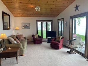 Relax in this stylish living room with a high ceiling, sofa, armchairs, and a coffee table.
