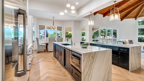 A modern kitchen with a large island, stainless steel appliances, and a herringbone wood floor. - ❤️️3 Min to Old Town❤️️Spectular Villa❤️️SwimBar❤️️PickleBall❤️️Golf❤️️Spa❤️️BBQ (Scottsdale)