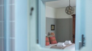 A bedroom with a bed, pillows, a lamp, and a hanging light fixture. - Merchants Town House - Catherine Hill (Frome)
