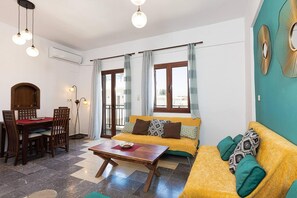 A living room with a wooden dining table, two sofas, and a coffee table.