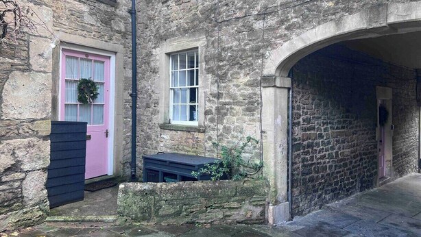 A stone building with a pink door and a small window. - Charming Weaver's Cottage in Historic Frome (Frome)