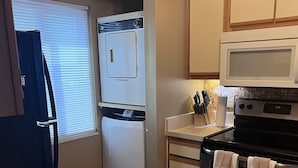 A compact kitchen with a refrigerator, microwave, oven, and a small countertop. - The Colony Condominiums Oceanfront Unit with Amazing Oceanfront Balcony (Virginia Beach)