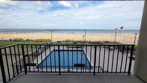 A pool area with a view of the beach and pier. - The Colony Condominiums Oceanfront Unit with Amazing Oceanfront Balcony (Virginia Beach)