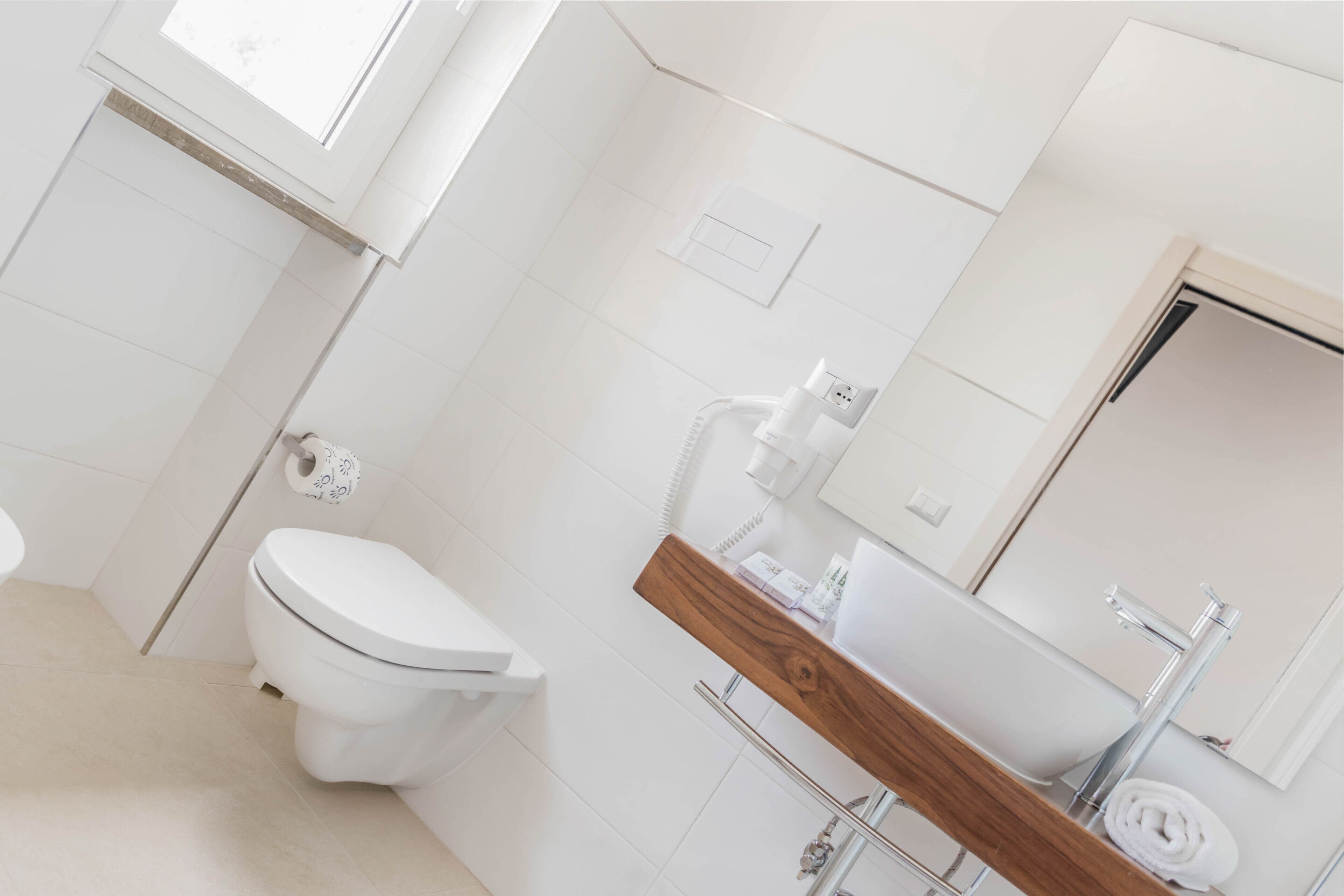 Een moderne badkamer met toilet, wastafel en spiegel.