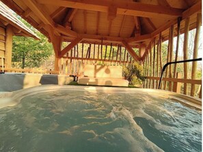 Ett område med ett bubbelbad, en träaltan och en bekväm sittgrupp.