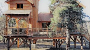 A wooden cabin with a balcony and a separate tower-like structure. - Cabane Château Luxe Jacuzzi/spa Privé - 2 à 6 Pers (Vieille-Brioude)