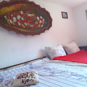 Comfortable bedroom with a large floral painting and floral-patterned bedding.