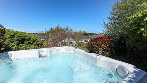 Un jacuzzi con vistas despejadas del jardín y las casas circundantes.